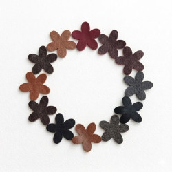 Genuine leather flower die cuts arranged in a circle on white background.